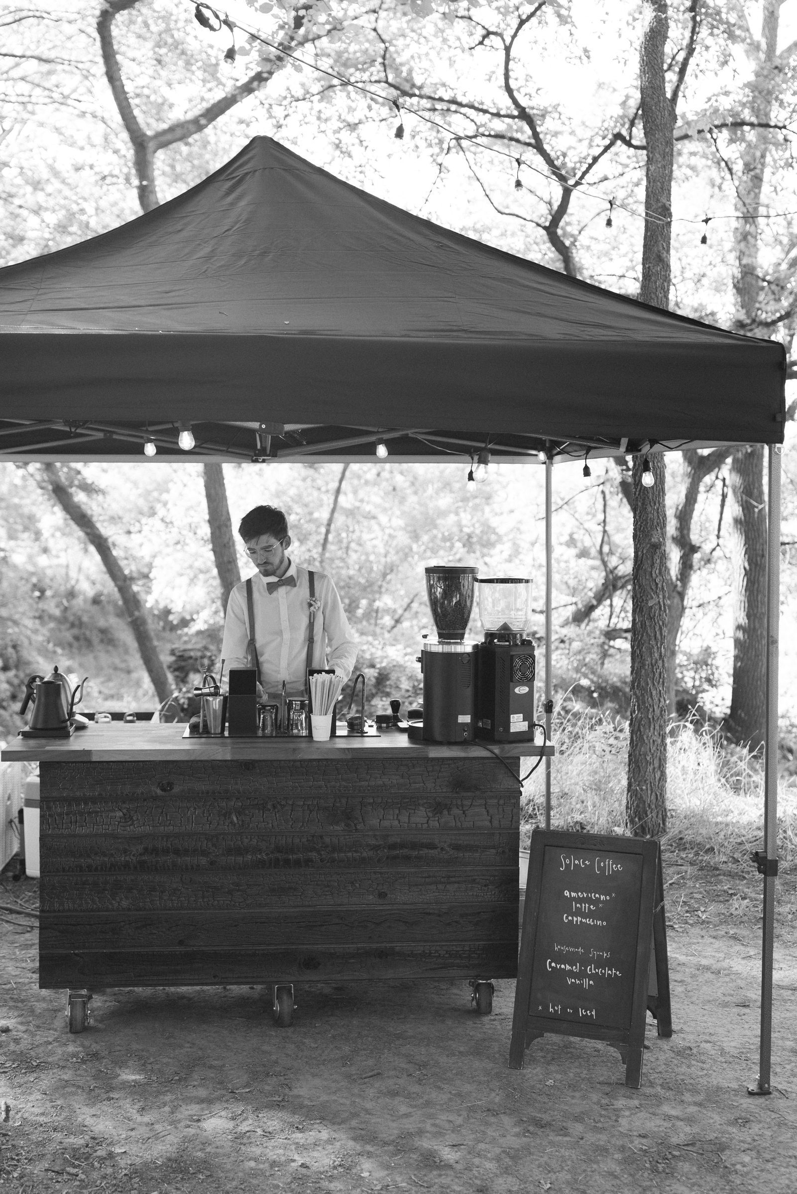 The Solace Coffee cart set up under a canopy, in black and white
